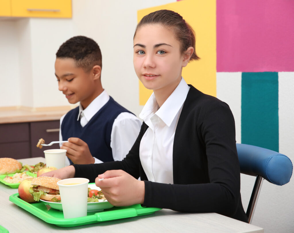 Kantin İşletme Belgesi Nasıl Alınır? 4 children sitting table school cafeteria while eating lunch 1